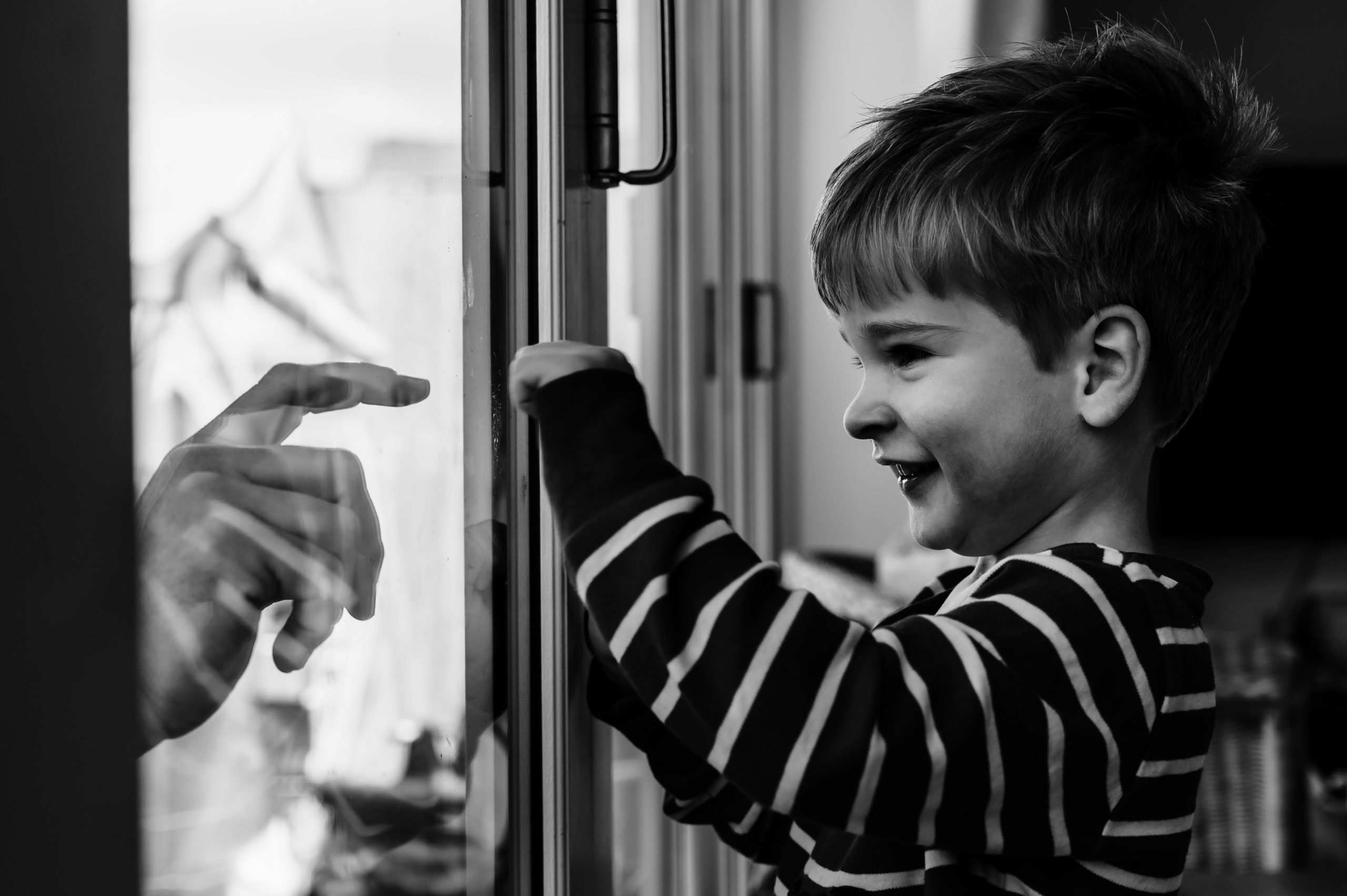 little boy playing in window with dad