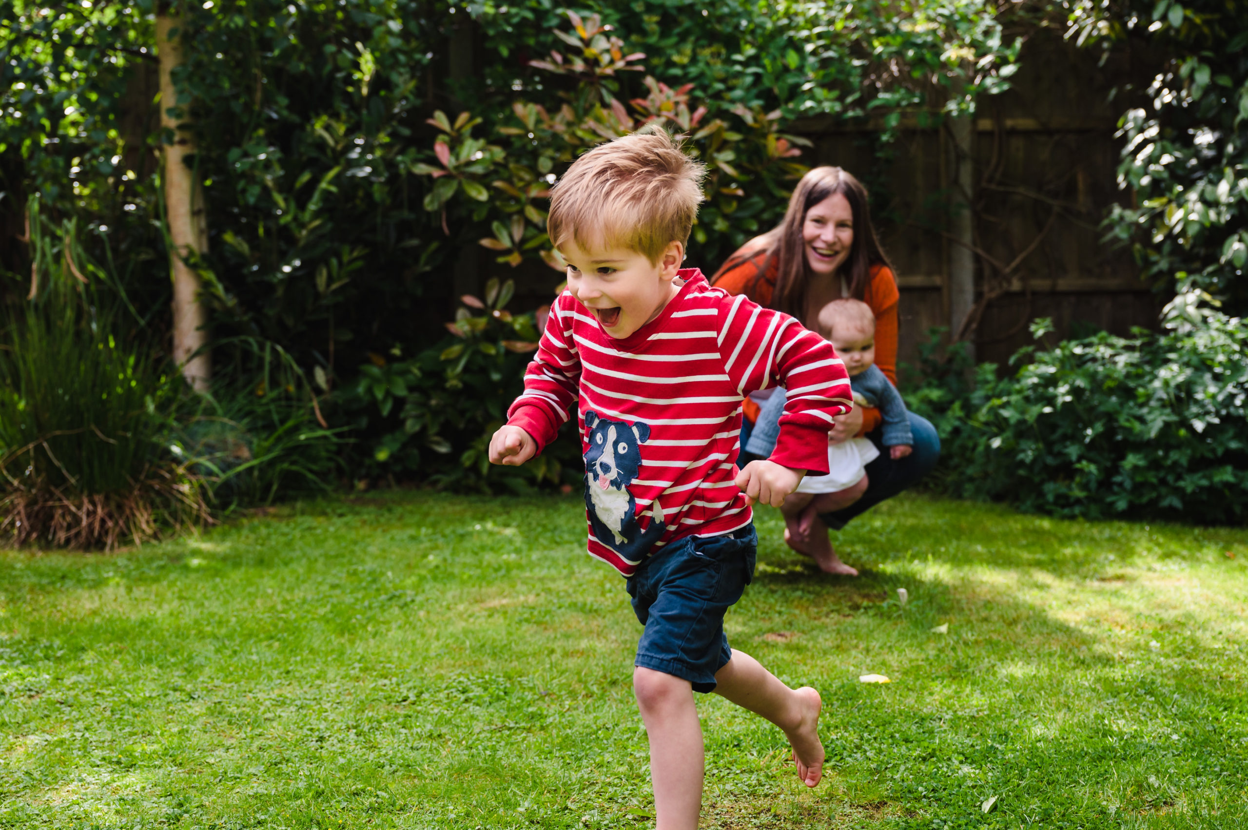 Little boy running across the garden