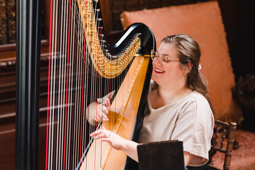 Harriet Flather playing the harp at Burgley house Rutland