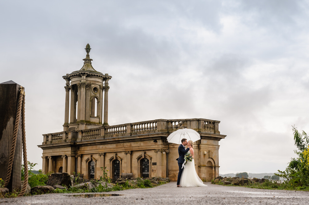 Bride and groom in the rain outside normanton church