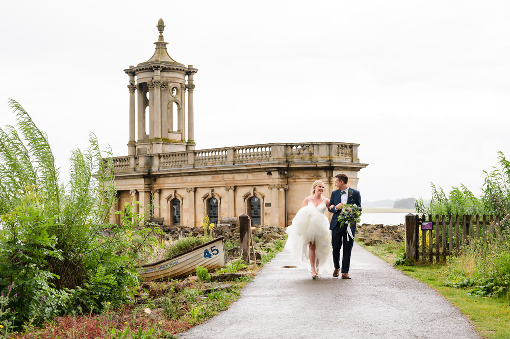 Bride and groom walking down the walkway to normanton church