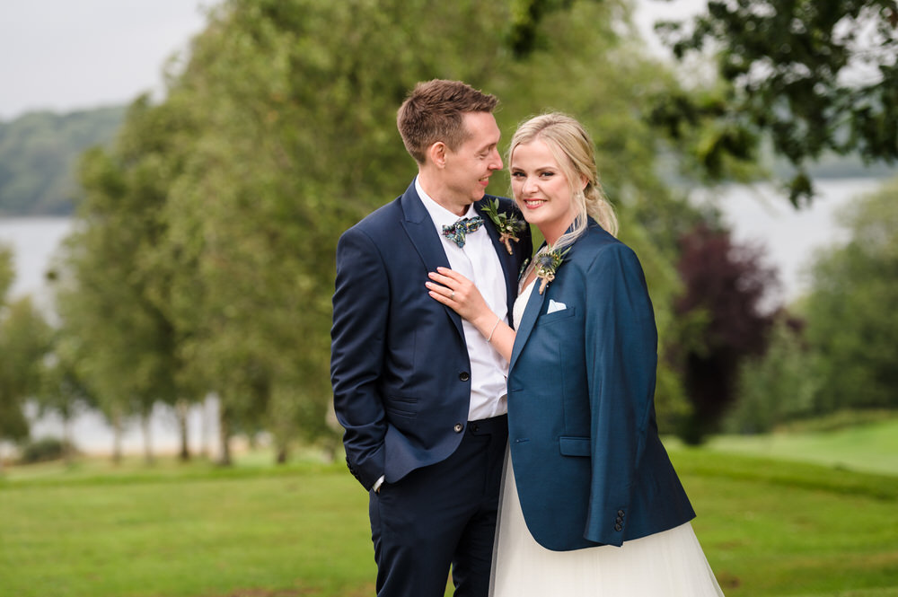 couple portrait at rutland water golf course bride is wearing grooms jacket