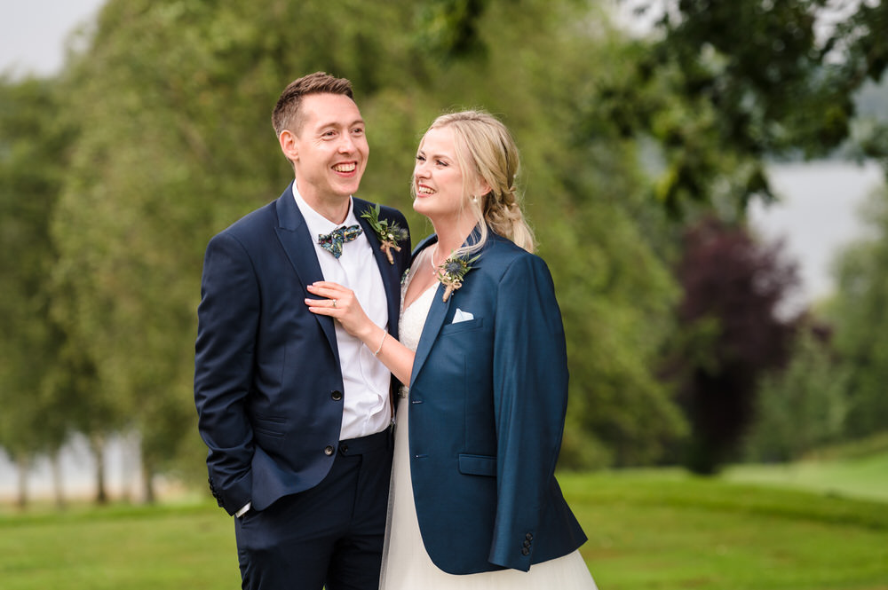 bride and groom laughing during couples portraits at rutland water golf course