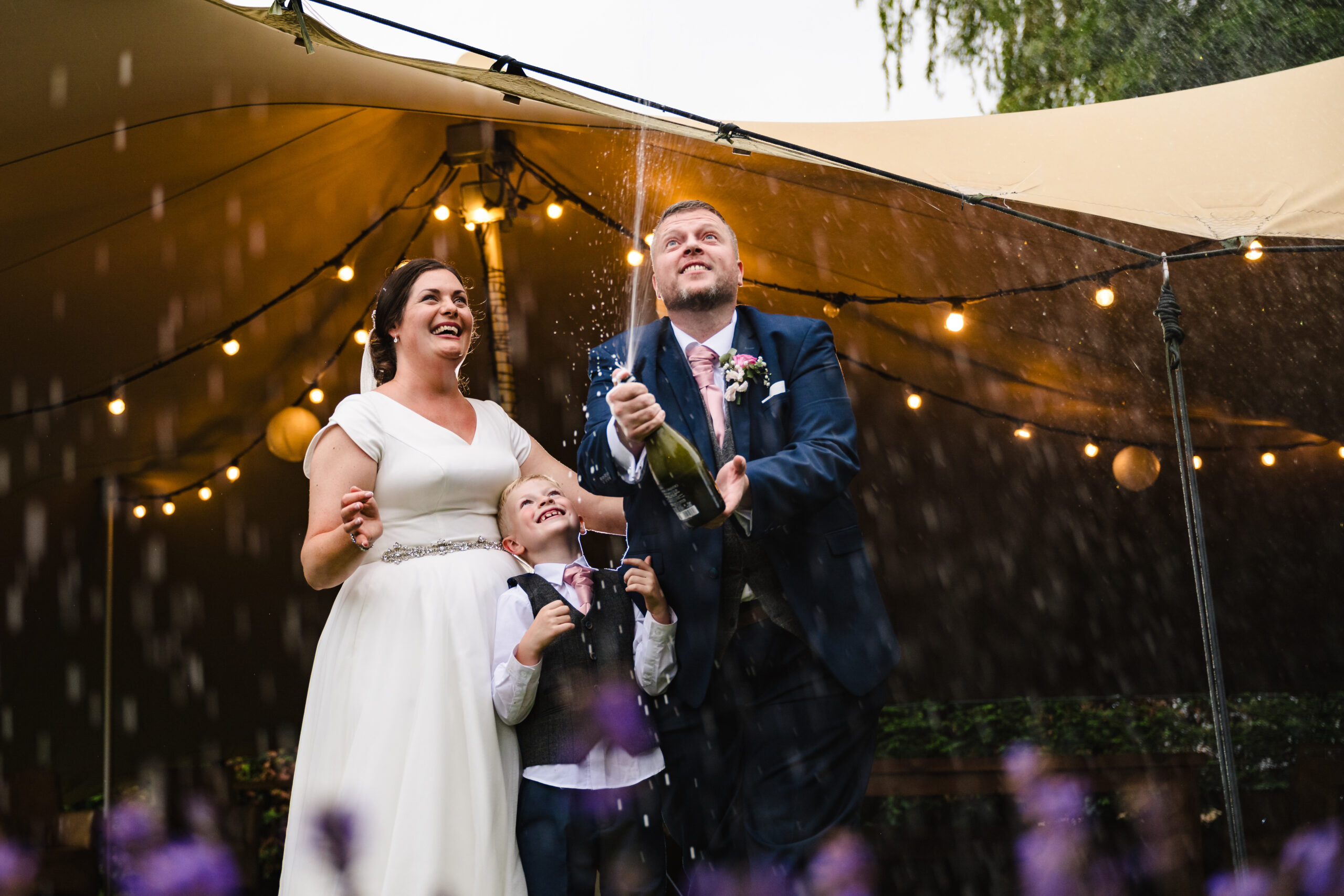 Couple popping champagne on their wedding day at chequers inn woolsthorpe