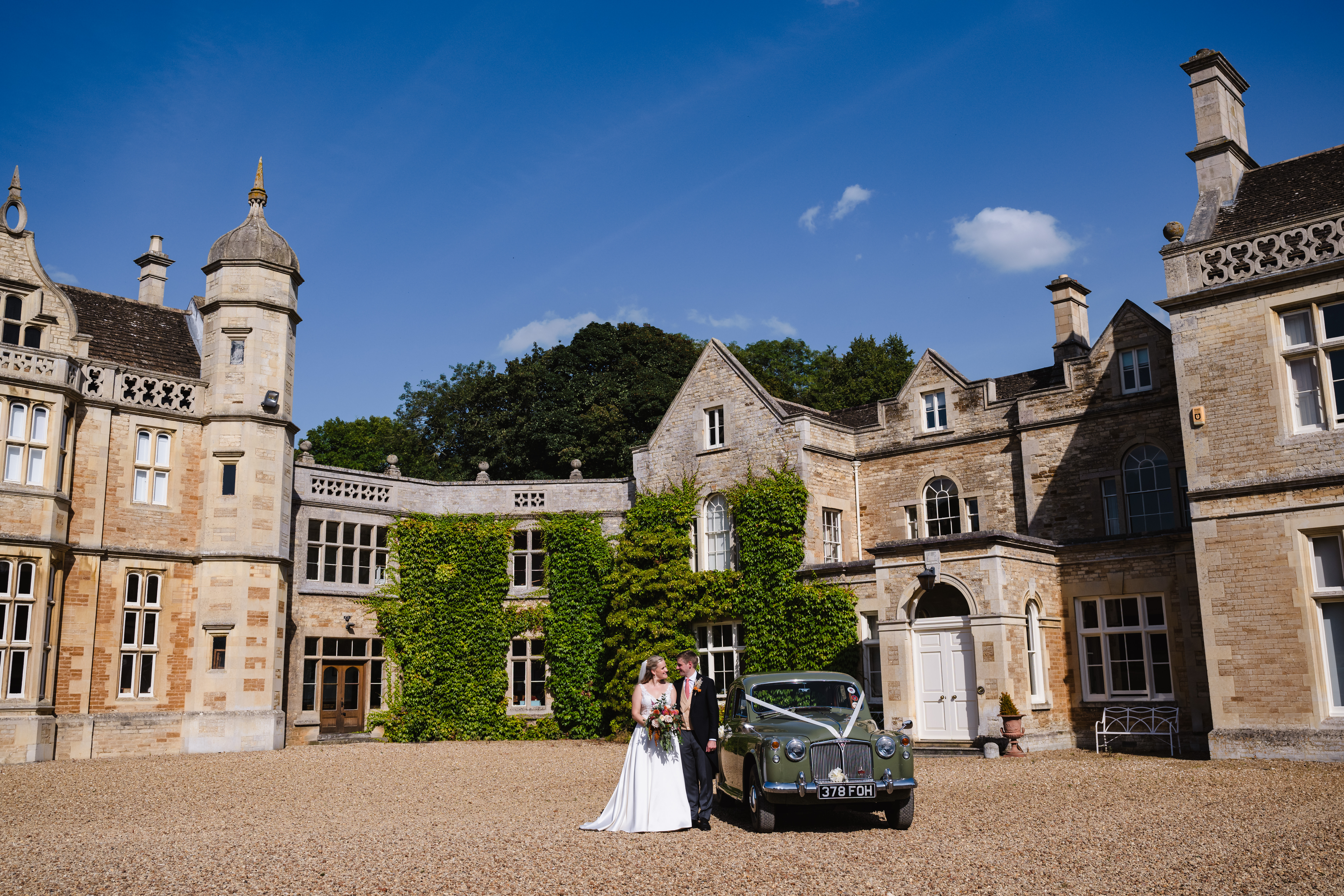 Bride and groom with wedding car in front of exton park rutland