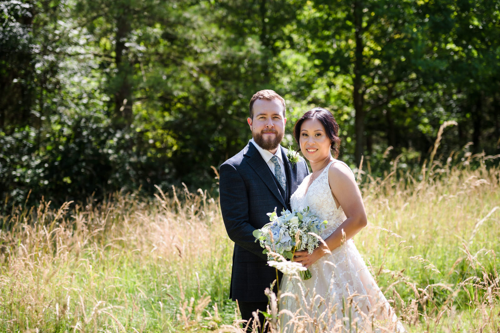 Bride and groom stood in long grass at fort henry