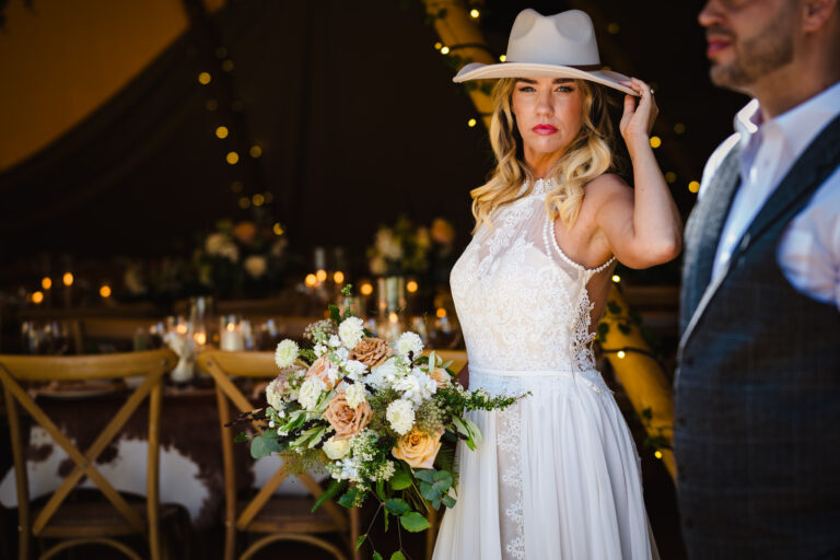 bride with cowboy hat on holding flowers at dibbins wood